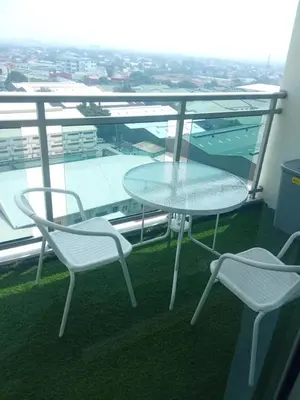 a glass table and two chairs on a balcony at Azure Urban Resort Residences in Manila