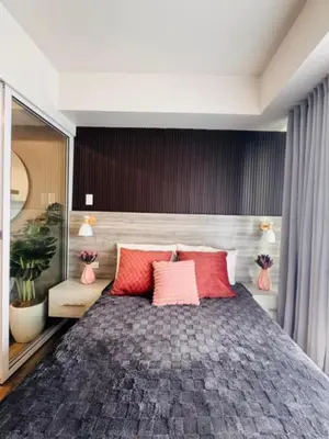 a bedroom with a large bed with red pillows at Azure Urban Resort Residences in Manila