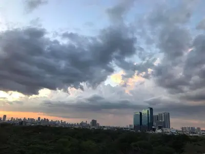 a city skyline under a cloudy sky with buildings at Cosy Studio with balcony 100mbps and Netflix in Manila