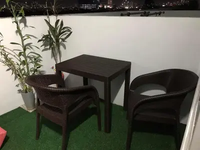 a black table and two chairs and a table and two plants at Cosy Studio with balcony 100mbps and Netflix in Manila