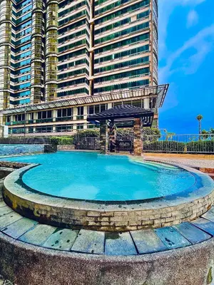 a swimming pool in front of a large building at Studio Unit at Grand Riviera Suites in front of US Embassy in Manila