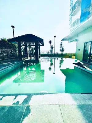 a swimming pool with a gazebo next to a building at Studio Unit at Grand Riviera Suites in front of US Embassy in Manila