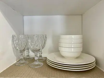 a shelf with plates and wine glasses on it at Studio Unit at Grand Riviera Suites in front of US Embassy in Manila