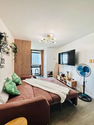 a bedroom with a large bed and a fan at Cozy and comfy place at Ortigas Pasig City in Manila