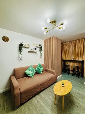 a living room with a brown couch and a table at Cozy and comfy place at Ortigas Pasig City in Manila