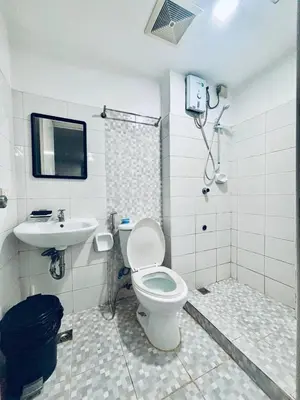 a bathroom with a toilet and a sink at Cozy and comfy place at Ortigas Pasig City in Manila