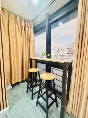 a balcony with a table and two stools in front of a window at Cozy and comfy place at Ortigas Pasig City in Manila