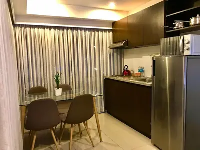 a kitchen with a table and chairs and a refrigerator at MaxStays - Max Home at Fort Victoria Tower A in Manila