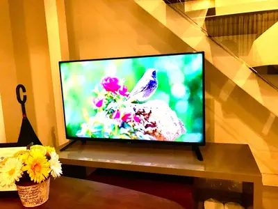 a flat screen tv sitting on a table with flowers at MaxStays - Max Home at Fort Victoria Tower A in Manila