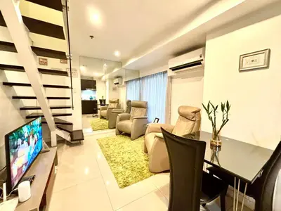 a living room with a couch and a tv in a room at MaxStays - Max Home at Fort Victoria Tower A in Manila