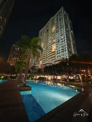 a large building with a swimming pool at night at Home of Poli - 1BR with FREE Netflix & WiFi in Manila