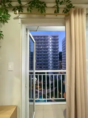 a window with a view of a city skyline at Cozy Place at Shell Residences in Manila