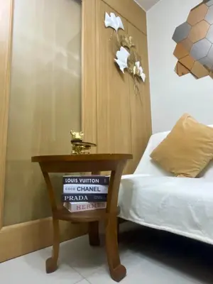 a bedroom with a bed and a table with a sign on it at Cozy Place at Shell Residences in Manila