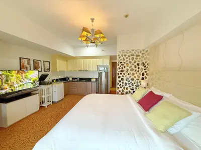 a large bedroom with a large white bed and a television at MaxStays - Max Home at The Venice Residences in Manila