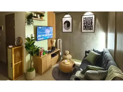 a living room with a blue couch and a tv at Philhaus Staycation 2025 in Manila