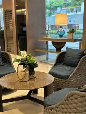 a lobby with two chairs and a table with flowers on it at marbys pad shore residences in Manila