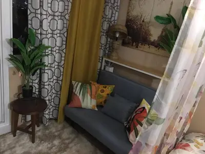 a blue couch with pillows in a living room at 5 minutes to Jazz Mall Studio-type condo100mbps in Manila