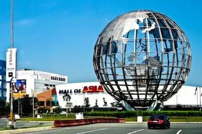 a car driving down a road with a large metal sphere at staycation condo one bedroom balcony w pool view near SMX SM MOA IKEA NAIA DFA OCEAN PARK in Manila