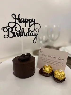 a chocolate cake and two cupcakes with a happy birthday sign at STAYCATION CONDO SHORE RESIDENCES one bedroom w balcony pool view near SMX SM MOA IKEA NAIA DFA OCEAN PARK DFA in Manila