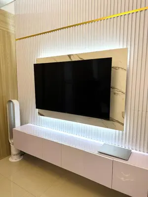 a flat screen tv hanging on a wall at STAYCATION CONDO SHORE RESIDENCES one bedroom w balcony pool view near SMX SM MOA IKEA NAIA DFA OCEAN PARK DFA in Manila