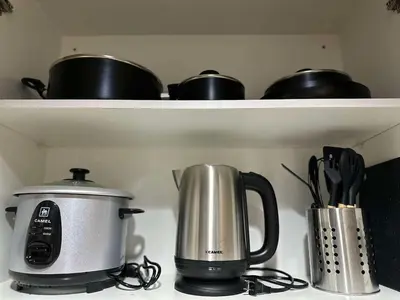 a coffee pot and a toaster on a shelf at STAYCATION CONDO SHORE RESIDENCES one bedroom w balcony pool view near SMX SM MOA IKEA NAIA DFA OCEAN PARK DFA in Manila