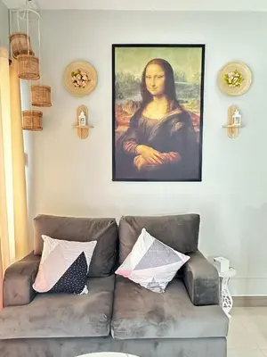 a living room with a couch and a painting on the wall at Les Chambres Cosy - Sea Residences MOA PASAY in Manila