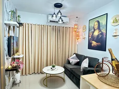 a living room with a couch and a table at Les Chambres Cosy - Sea Residences MOA PASAY in Manila