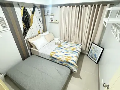 a small bedroom with a bed and a window at Les Chambres Cosy - Sea Residences MOA PASAY in Manila