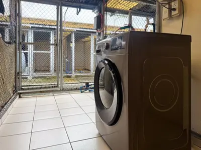 a washing machine sitting on a tiled floor at Functional stay near airport, business districts in Manila