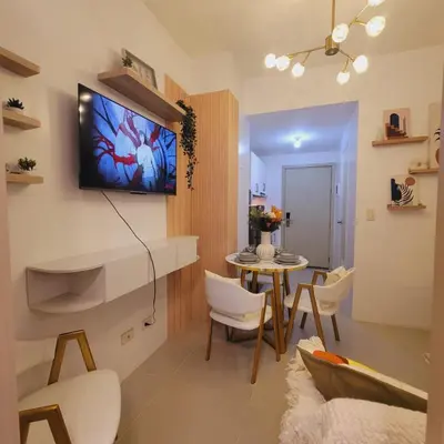 a living room with a table and a tv on the wall at Fourth's Jazz Cozy Pad in Manila
