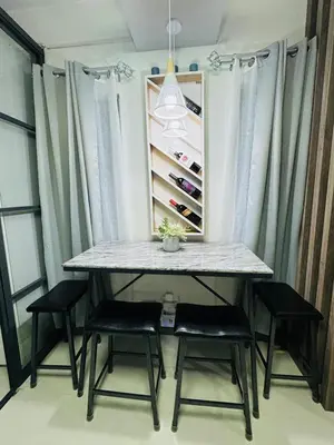 a table and chairs in a room with windows at KD's Home - Fast WiFi, Netflix , Pool , Karaoke in Manila