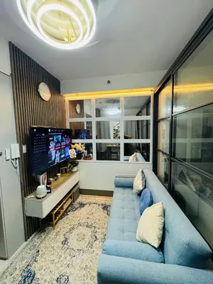 a living room with a blue couch and a tv at KD's Home - Fast WiFi, Netflix , Pool , Karaoke in Manila