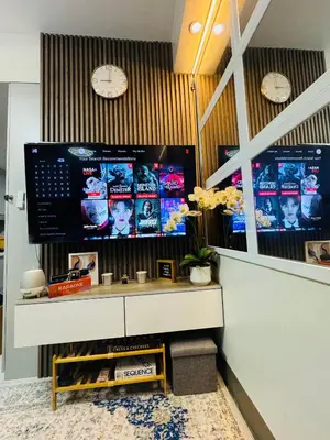 a room with a counter with a tv on the wall at KD's Home - Fast WiFi, Netflix , Pool , Karaoke in Manila
