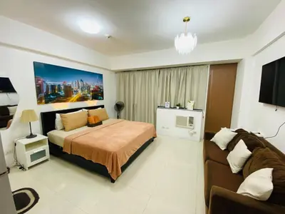 a bedroom with a bed and a couch at Bekipay Suite at One Palm Tree right across NAIA 3 in Manila