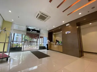 a lobby of a building with a person standing at a counter at Bekipay Suite at One Palm Tree right across NAIA 3 in Manila