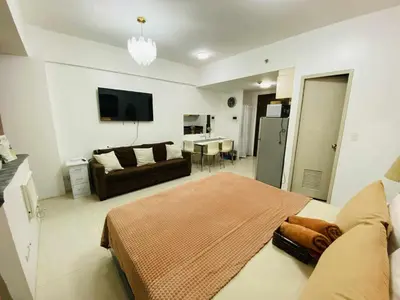 a living room with a bed and a couch at Bekipay Suite at One Palm Tree right across NAIA 3 in Manila