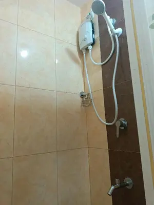 a shower in a bathroom with a shower head at Gale Haven in Manila