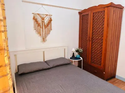 a bedroom with a bed and a wooden cabinet at Stan Condo in Manila