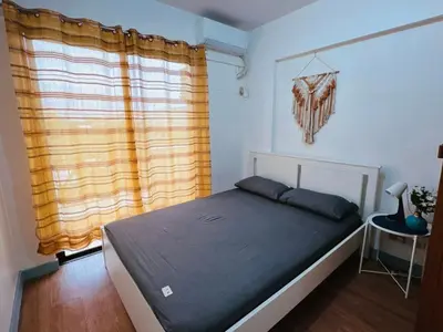 a bedroom with a bed and a window at Stan Condo in Manila