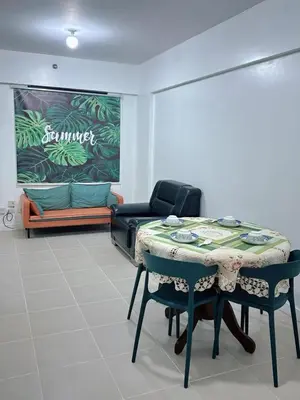 a room with a table and chairs and a couch at Stan Condo in Manila