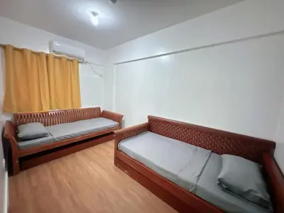 a room with two beds and a window in it at Stan Condo in Manila