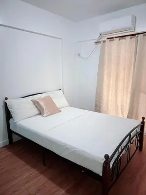 a small bed in a room with a window at Vtan Condo in Manila