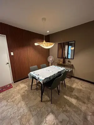 a dining room with a table and chairs and a light at 4Br House in Pasay near airport in Manila