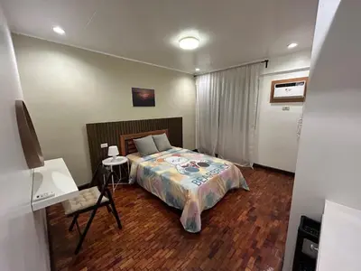 a bedroom with a bed and a desk in it at 4Br House in Pasay near airport in Manila