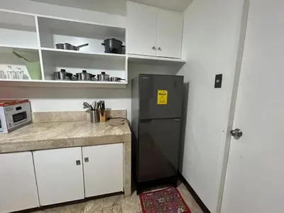 a kitchen with a black refrigerator and white cabinets at 4Br House in Pasay near airport in Manila