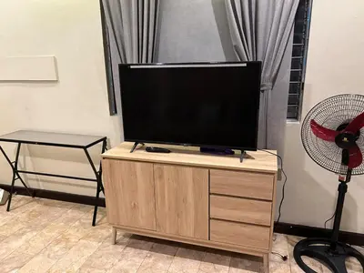 a flat screen tv sitting on top of a wooden cabinet at 4Br House in Pasay near airport in Manila