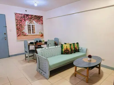 a living room with a couch and a table at Arista place staycation in Manila
