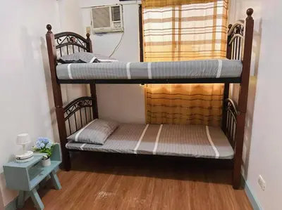 two bunk beds in a room with a window at Arista place staycation in Manila