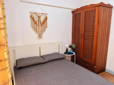 a bedroom with a bed and a wooden cabinet at Arista place staycation in Manila