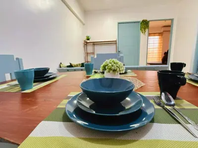 a table with blue bowls and plates on it at Arista place staycation in Manila